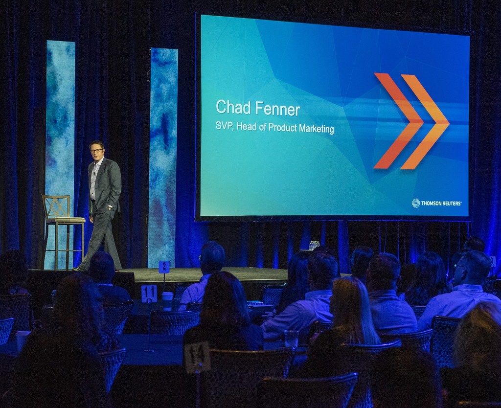 Chad Fenner presenting onstage at an executive conference